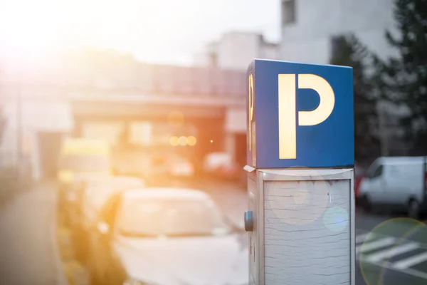 Parken in der Innenstadt: Parkautomat, Abendkulisse und Autos. s — Stockfoto