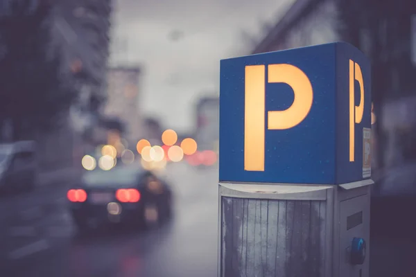 Parken in der Innenstadt: Parkautomat, Abendkulisse und Autos — Stockfoto
