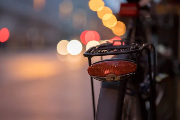 Bike in the city, dusk: Rear picture of a city bike, blurred bac — Stock Photo, Image