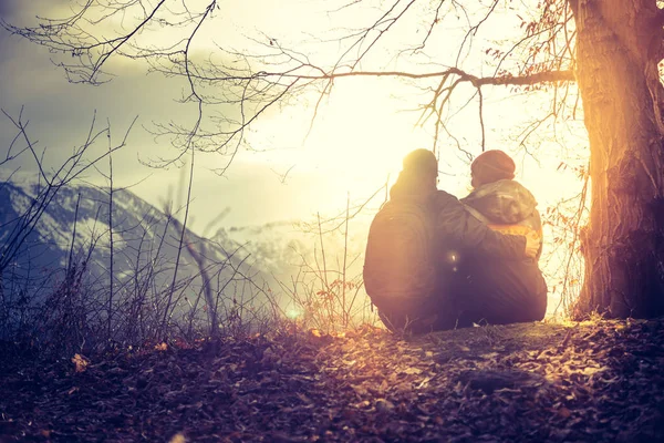 Idylická horská krajina: mladí sedící dvojice se těší — Stock fotografie