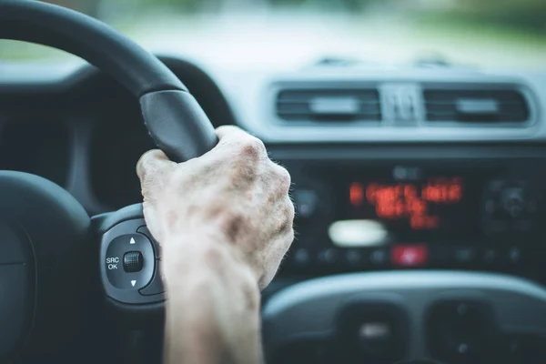 Interior del coche moderno: manos masculinas en un volante deportivo — Foto de Stock
