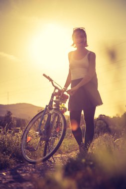 Akşam güneşi, günbatımı sahne zevk: bisiklet ile kadın st