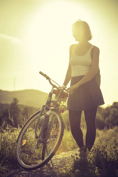 Élvezi az esti nap, naplemente díszletek: nő, kerékpár — Stock Fotó