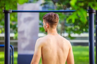 Yaz aylarında egzersiz: Genç fit Kafkas adam pull up yapıyor 