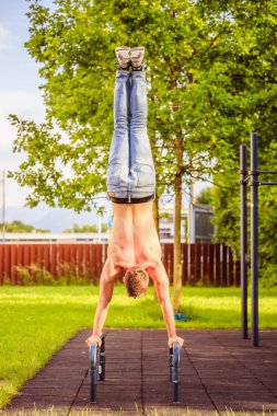 Yaz aylarında egzersiz: Genç fit Kafkas adam bir handstand yapıyor 