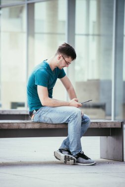 Kampüste tablet bilgisayar kullanan öğrenci. Açık havada, kentsel duygu