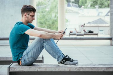 Kampüste tablet bilgisayar kullanan öğrenci. Açık havada, kentsel duygu