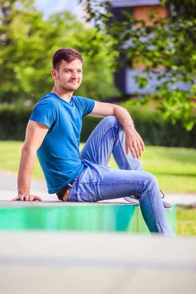 Hombre joven empleado está sentado al aire libre, tomando un descanso — Foto de Stock