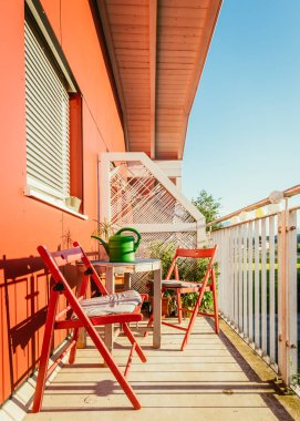 Rahat yaz balkon: Kırmızı sandalye, güneş, kimse