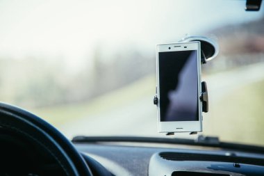 Navigasyon cihazı olarak kullanılan akıllı telefon ile araç panosu, parlak 