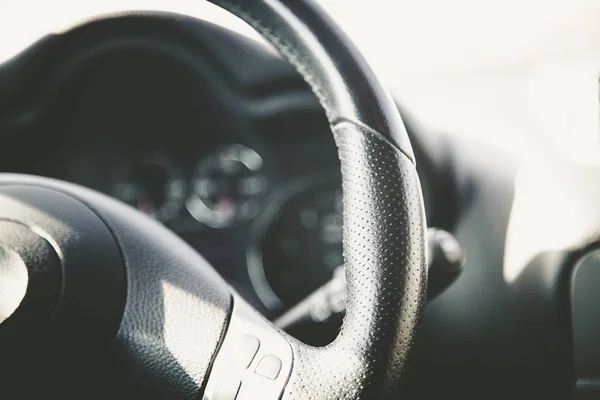 Volant d'une voiture moderne, tableau de bord flou — Photo