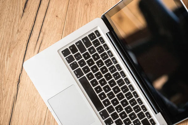 Laptop em uma mesa de madeira rústica, escritório em casa — Fotografia de Stock