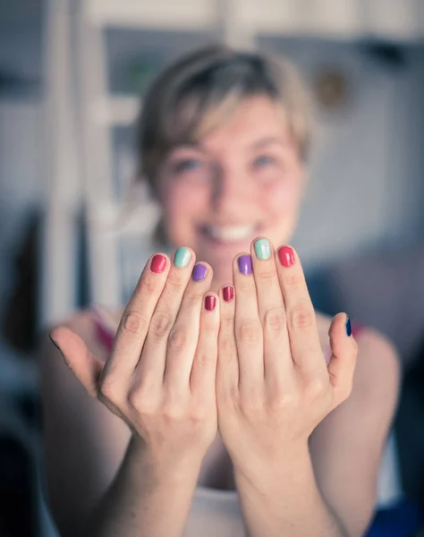 Mooie jonge vrouw met kleurrijke nagellak. Lachend gezicht in th — Stockfoto