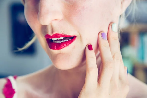 Atractivo labio rojo palo: Mujer joven rubia con uñas de colores —  Fotos de Stock