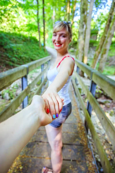 Dobrodružství v lese: dívka drží v ruce své přítele — Stock fotografie