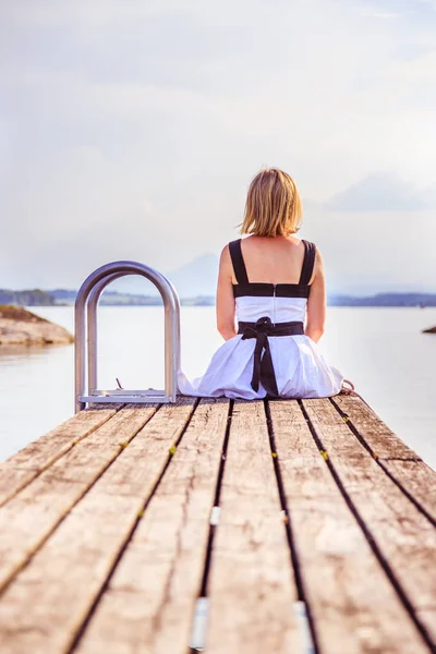 Mulher bonita com vestido branco está sentado em um footbridg — Fotografia de Stock