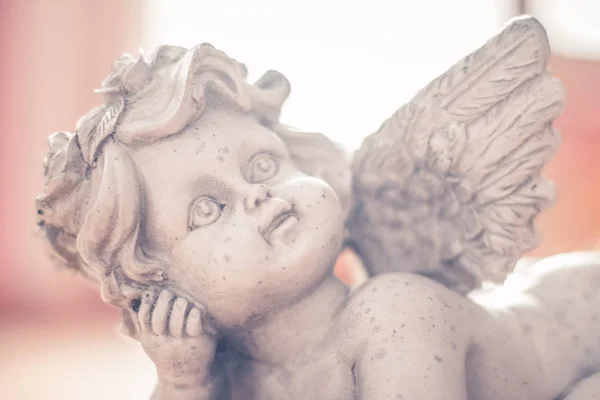 Sculpture of a white guardian angel lying on the wooden floor Royalty Free Stock Images