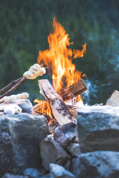 Выпечка хлеба над огнем: барбекю на открытом воздухе с костром — стоковое фото