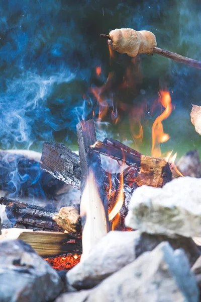 Cuisson du pain au-dessus du feu : Barbecue à l'extérieur avec un feu de joie — Photo