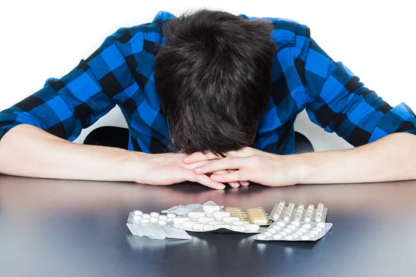 Hombre deprimido tomando drogas. Joven sentado en una mesa, drogas —  Fotos de Stock