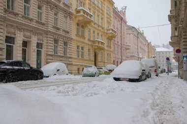 Kaygan bir yolda karla kaplı arabalar.
