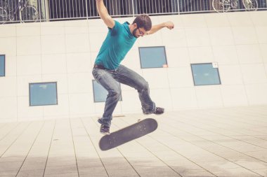 Erkek kaykaycı atlama numarası yapıyor.