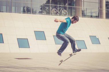 Erkek kaykaycı atlama numarası yapıyor.