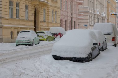 Kaygan bir yolda karla kaplı arabalar.