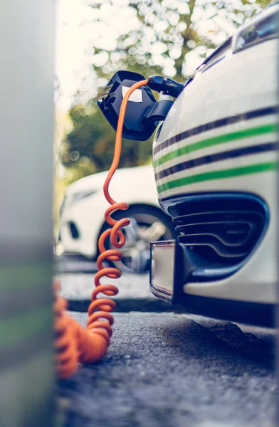 Power supply for electric car charging. Electric car charging station. Close up of the power supply plugged into an electric car being charged