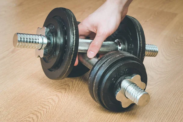 dumbbells and hand on the wooden table background