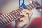 Detailní záběr muže hrajícího na kytaru