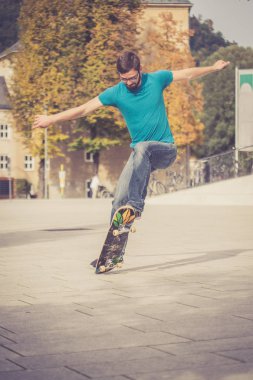 Erkek kaykaycı atlama numarası yapıyor.