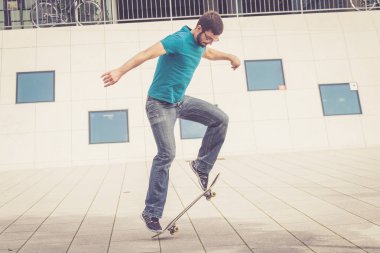 Erkek kaykaycı atlama numarası yapıyor.