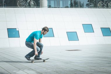 Erkek kaykaycı atlama numarası yapıyor.