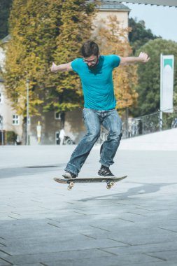 Erkek kaykaycı atlama numarası yapıyor.