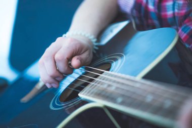 Bir sunburst batı gitar çalan genç adam