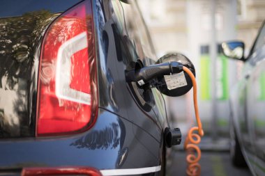 Elektrikli araba şarjı için güç kaynağı. Elektrikli araba şarj istasyonu. Şarj edilen bir elektrikli arabaya takılan güç kaynağını kapatın.