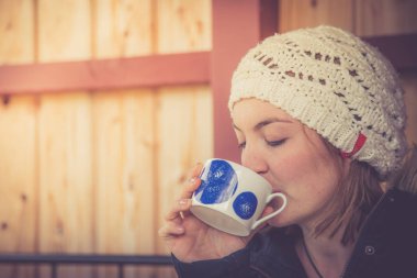 Genç bayan kışın kahve içiyor.