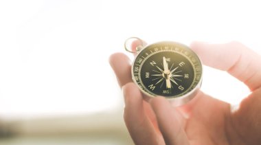 Erkeklerin elindeki klasik pusula, macera ve keşif konsepti  