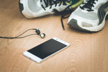 Spor aletleri ve akıllı telefon ahşap masada.