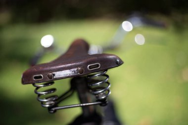 Arka planda deri bisiklet eyeri, yakın çekim.