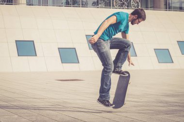 Erkek kaykaycı atlama numarası yapıyor.