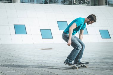 Erkek kaykaycı atlama numarası yapıyor.