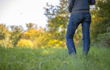 Yeşil çimlerin üzerinde duran bir adam