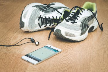 Spor aletleri ve akıllı telefon ahşap masada.