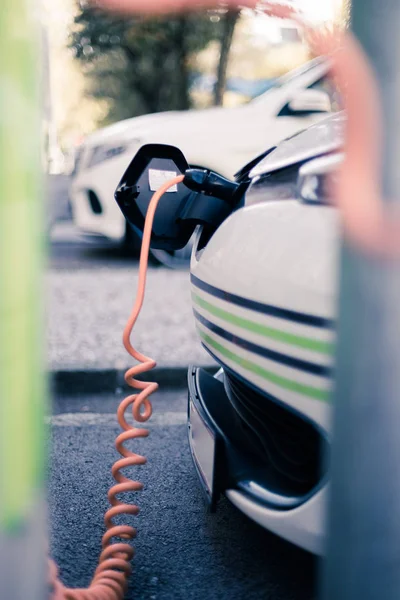 Electric car recharging with charge cable and plug leading to charge point