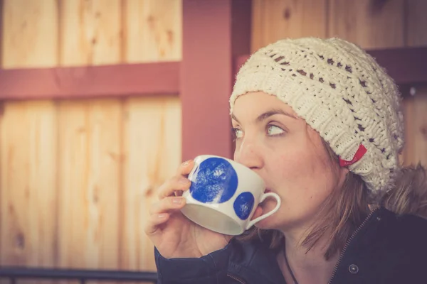 young woman drinking coffee in the winter