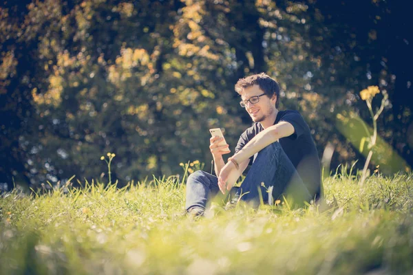 Muž Relaxuje Zelené Trávě Venku Telefonem — Stock fotografie