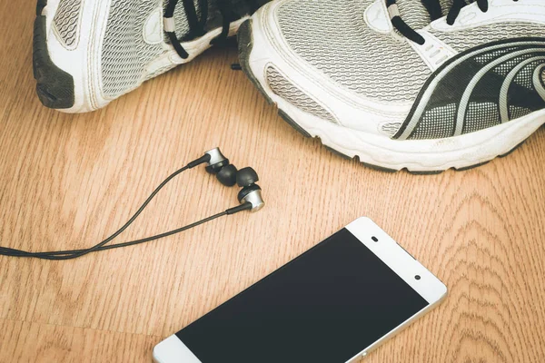 Spor aletleri ve akıllı telefon ahşap masada.