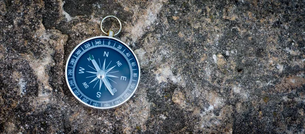 Abenteuer: Kompass liegt auf dem Boden und zeigt die Richtung an — Stockfoto